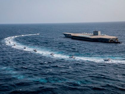 In this photo released Tuesday, July 28, 2020, by Sepahnews, Revolutionary Guard's speed boats circle around a replica aircraft carrier during a military exercise. Iran's paramilitary Revolutionary Guard has fired a missile from a helicopter targeting the mock-up aircraft carrier in the strategic Strait of Hormuz according to footage aired …