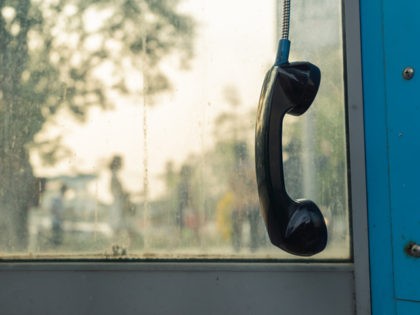 Telephone receiver hanging in phone booth