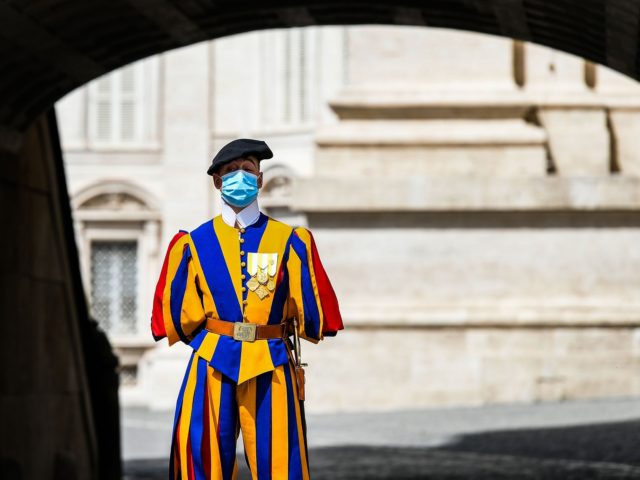 A Swiss Guard wearing a face mask stands guard by St. Peter's Basilica as it reopens on May 18, 2020 in The Vatican during the lockdown aimed at curbing the spread of the COVID-19 infection, caused by the novel coronavirus. - Saint Peter's Basilica throws its doors open to visitors …