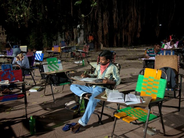 In this Friday, Feb. 17, 2017 photo, P. Venkateshwarlu, a 27-year old graduate preparing for a government accountant's job, studies in an open ground outside the City Central Library in Hyderabad, India. Hundreds of young college students and job-seekers, armed with their books and other study material sit and prepare …