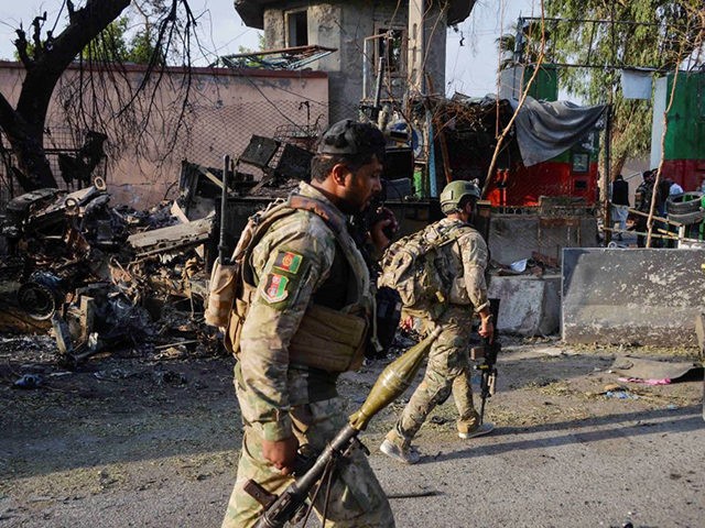 In this picture taken on August 3, 2020, Afghan soldiers walk past debris near the main en