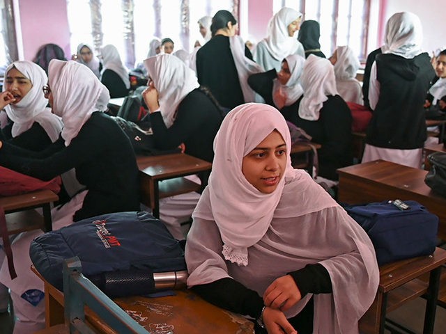 Students talk to each other inside a classroom as schools in Kashmir re-opened after a win