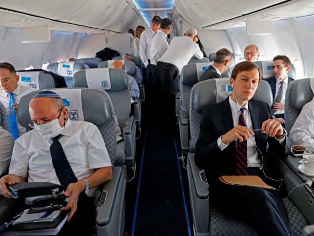 TOPSHOT - US Presidential Adviser Jared Kushner (C) and US National Security Adviser Robert OBrien (R) and Head of Israel's National Security Council Meir Ben-Shabbat (L) sit in their seat in the El Al's airliner, which is carrying a US-Israeli delegation to the UAE following a normalisation accord, upon landing …