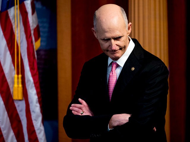 FILE - In this March 25, 2020, file photo Sen. Rick Scott, R-Fla., attends a news conference about the coronavirus relief bill on Capitol Hill in Washington. Scrambling to address voting concerns amid a pandemic, election officials from Nevada to Florida are scaling back or eliminating opportunities for people to …