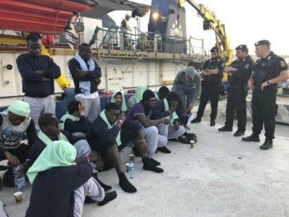 FILE -- In this file photo migrants sit on the quay after disembarking at Lampedusa harbor, Italy, on June 29, 2019. Small boats filled with more Tunisian migrants have reached a tiny Italian island, which had no room to quarantine them Saturday, Aug. 1, 2020, amid the pandemic. Sicilian daily …