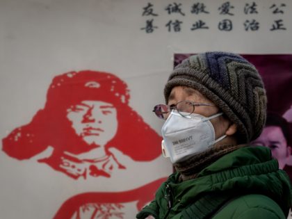 A woman wearing a protective mask to help stop the spread of a deadly virus which began in Wuhan, stands outside Beijing railway station in Beijing on January 27, 2020. - China on January 27 extended its biggest national holiday to buy time in the fight against a viral epidemic …