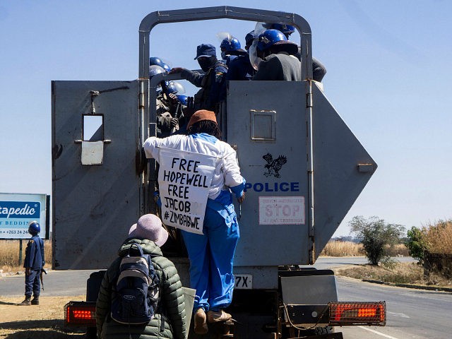 Zimbabwean novelist Tsitsi Dangarembga (C) and a colleague Julie Barnes hold placards as t