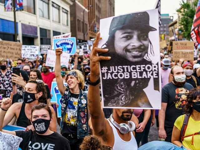 Protesters march near the Minneapolis 1st Police precinct during a demonstration against police brutality and racism on August 24, 2020 in Minneapolis, Minnesota. - It was the second day of demonstrations in Kenosha after video circulated Sunday showing the shooting of Jacob Blake -- multiple times, in the back, as he …
