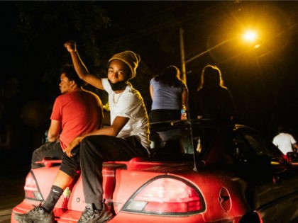 Demonstrators sit on top of a car during a march on August 26, 2020 in Kenosha, Wisconsin.