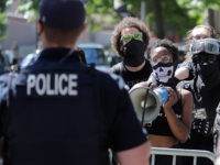 A Black Lives Matter protester holds a megaphone during a counter-protest to a rally in support of police and other law enforcement officers, Wednesday, July 15, 2020, in front of City Hall in Seattle. (AP Photo/Ted S. Warren)