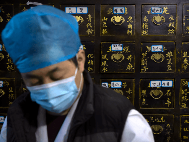 In this March 13, 2020 photo, a worker fills orders for prescriptions in front of a cabinet of drawers containing ingredients for traditional Chinese medicine preparations at the Bo Ai Tang traditional Chinese medicine clinic in Beijing. With no approved drugs for the new coronavirus, some people are turning to …