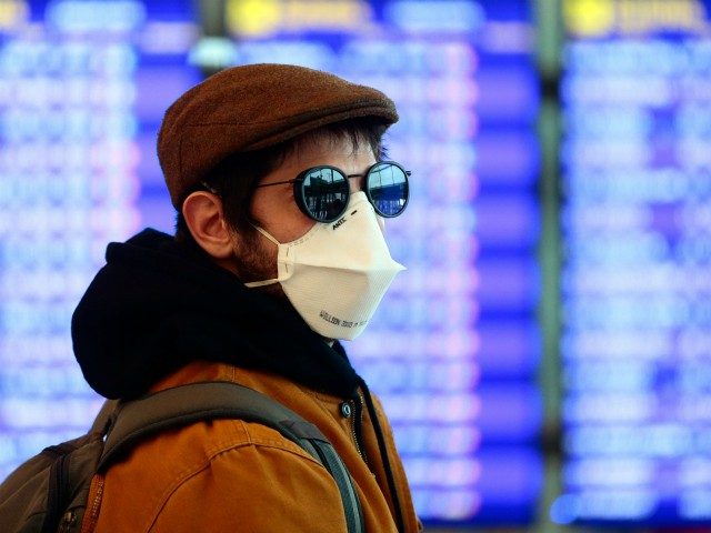 A man wearing a protective mask walks at the Terminal 1 of El Prat airport in Barcelona on