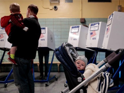 A baby waits as people vote at a polling site at Public School 261, November 8, 2016 in New York City. Citizens of the United States will choose between Republican presidential candidate Donald Trump and Democratic presidential candidate Hillary Clinton. (Photo by Drew Angerer/Getty Images)