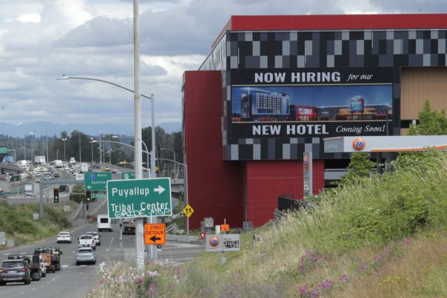 In this July 9, 2020, file photo, a large video display reads "Now hiring for our new hotel coming soon!," at the new Emerald Queen Casino, which is open, and owned by the Puyallup Tribe of Indians, in Tacoma, Wash. The United States added 1.8 million jobs in July, a …