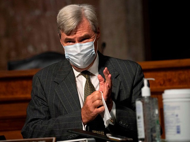Sen. Sheldon Whitehouse, D-RI, wears a facemask and cleans his hands with a disinfecting wipe as he arrives during the start of a Senate Judiciary Committee oversight hearing on Capitol Hill in Washington,DC on August 5, 2020, to examine the Crossfire Hurricane investigation. (Photo by Carolyn Kaster / POOL / …