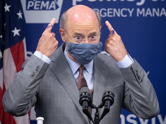 Pennsylvania Governor Tom Wolf removes his mask before answering questions from the press.