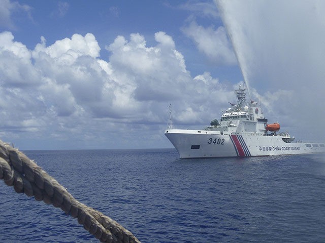 FILE - In this Sept. 23, 2015, file photo, Chinese Coast Guard members approach Filipino f