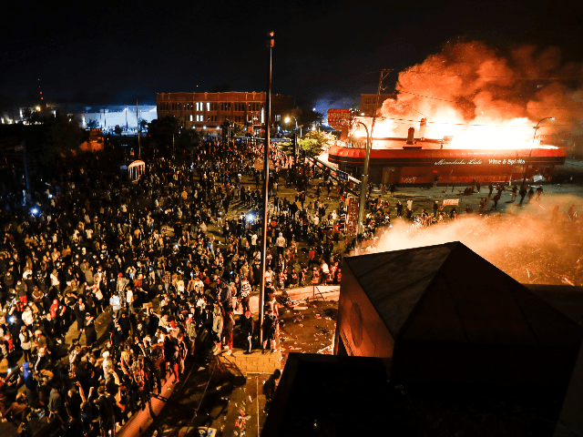Protestors demonstrate outside of a burning Minneapolis 3rd Police Precinct, Thursday, May