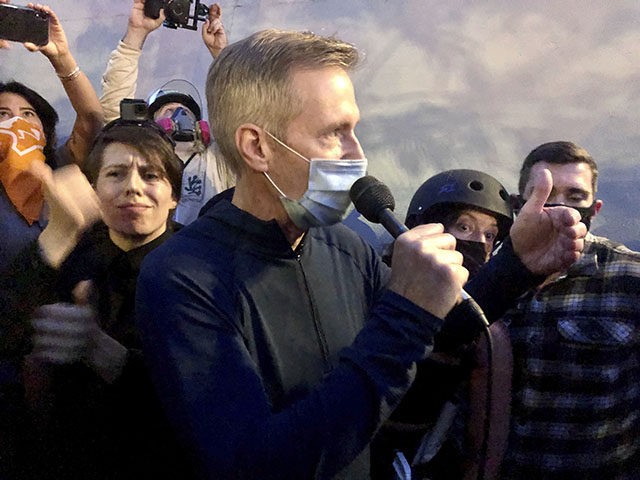 Mayor Ted Wheeler speaks to people gathered in downtown Portland, Ore., Wednesday, July 22, 2020. Wheeler faced a hostile crowd of protesters, who screamed at and sharply questioned him as he tried to rally demonstrators who have clashed repeatedly with federal agents sent in by President Donald Trump to quell …