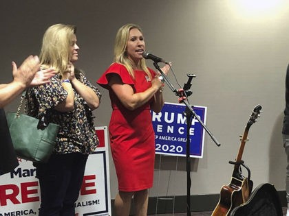 Construction executive Marjorie Taylor Greene, third from left, claps with her supporters at a watch party event, late Tuesday, Aug. 11, 2020, in Rome, Ga. Greene, criticized for promoting racist videos and adamantly supporting the far-right QAnon conspiracy theory, won the GOP nomination for northwest Georgia's 14th Congressional District. (AP …