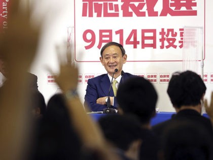 Japanese Chief Cabinet Secretary Yoshihide Suga, center, smiles as reporters raise hands for questions during a press conference for the ruling Liberal Democratic Party leadership election at the party headquarters in Tokyo, Tuesday, Sept. 8, 2020. Official campaigning to choose outgoing Prime Minister Shinzo Abe’s successor to lead his ruling …