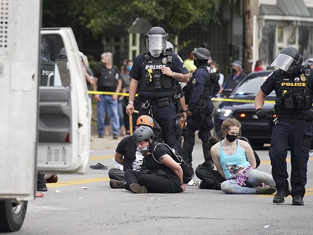 Louisville police detain a a group who marched, Wednesday, Sept. 23, 2020, in Louisville,
