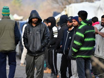Migrants walk among tents, at improvised camp "Vucjak", in the outskirts of Northern-Bosnian town of Bihac, early on December 9, 2019. - After EU urged that "Vucjak" is too close to the EU border and deemed that living conditions in the camp are inhumane, Bosnian authorities have announced that migrants …