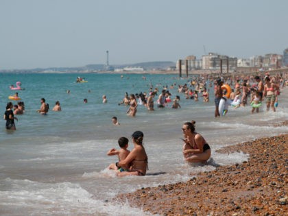 Beachgoers enjoy the sunshine and sea on what is now Britain's hottest day of the year so far, in Brighton, England, Friday, July 31, 2020. Temperatures have reached 35C (95F) at London's Heathrow Airport. (AP Photo/Alastair Grant)