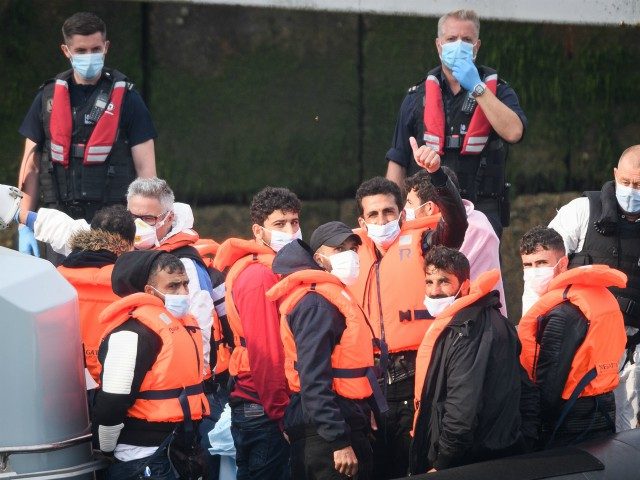 DOVER, ENGLAND - AUGUST 11: A migrant gives a thumbs up after crossing the English Channel