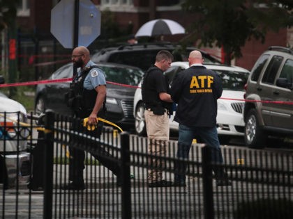 CHICAGO, ILLINOIS - JULY 21: An ATF agent and Police investigate the scene of a shooting in the Auburn Gresham neighborhood on July 21, 2020 in Chicago, Illinois. At least 14 people were transported to area hospitals after several gunmen opened fire on mourners standing outside of a funeral home. …