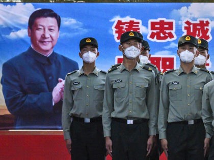 BEIJING, CHINA - MAY 20: Soldiers of the People's Liberation Army's Honour Guard Battalion wear protective masks as they stand at attention in front of photo of China's president Xi Jinping at their barracks outside the Forbidden City, near Tiananmen Square, on May 20, 2020 in Beijing, China. China's government …