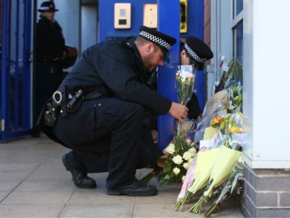 LONDON, ENGLAND - SEPTEMBER 25: Metropolitan Police collect floral tributes at Croydon Custody Centre on September 25, 2020 in the Croydon area of London, England. A murder investigation has been launched following the death of a police officer at the Croydon Custody Centre in south London. He was shot by …