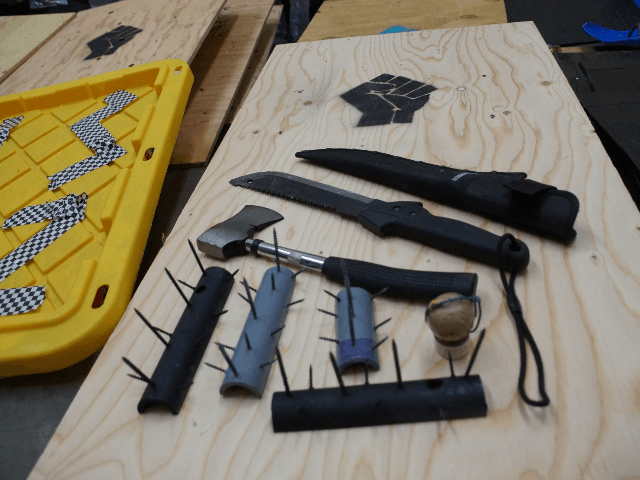 Officers recover weapons, shields, and spike strips during park cleanup.