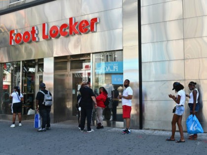 People wait in line to enter Foot Locker store on June 22, 2020 in the Brooklyn Borough of New York City. - New York City begins Phase Two reopening on June 22, 2020 as people can eat outdoors at restaurants and barbershops and salons can also open at 50 percent …
