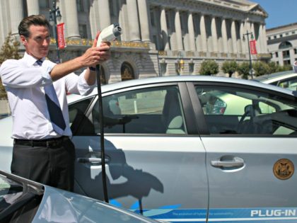 SAN FRANCISCO - AUGUST 25: San Francisco mayor Gavin Newsom holds a power cable before test driving a plug-in version of the popular Toyota Prius that is one of four on loan to the city for evaluation August 25, 2010 in San Francisco, California. With sales of electric and plug-in …