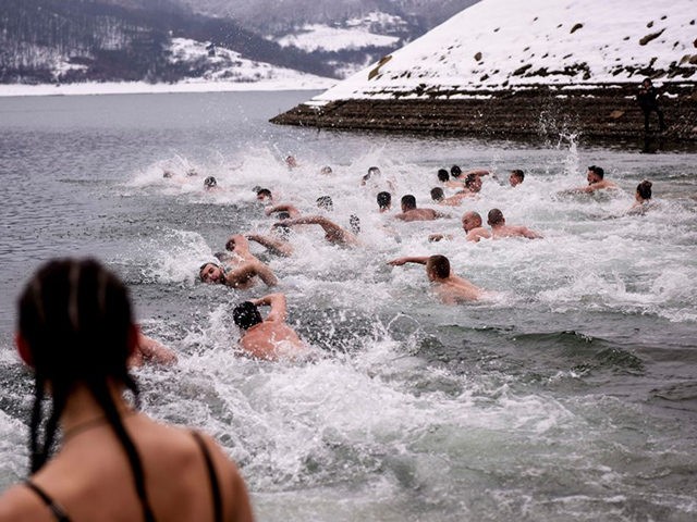 People swim in the cold water of the Gazivoda lake as they take part in the traditional Epiphany swimming competition, near the Kosovan town of Zubin Potok, in northern Mitrovica, on January 19, 2019. - According to a popular belief, the first man to pick up the cross, thrown on …