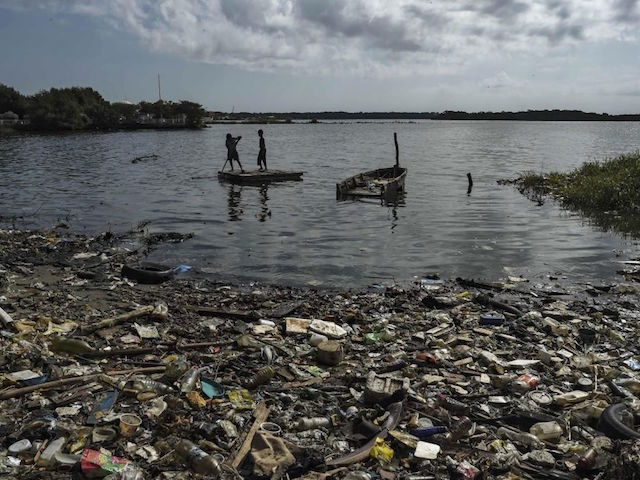 Children sail on a raft in the polluted waters of the Maracaibo Lake, in Maracaibo, Zulia