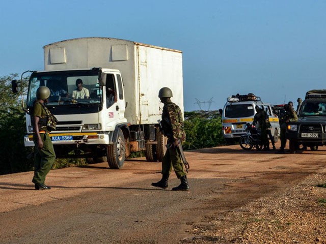 Kenyan police officers check vehicles on a road after a bus, travelling from the coastal r