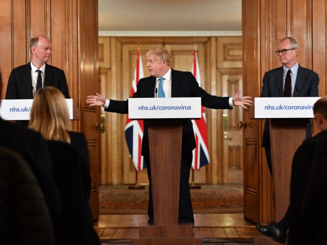 LONDON, ENGLAND - MARCH 19: Chief Medical Officer Professor Chris Whitty (L) and Chief Scientific Adviser Patrick Vallance (R) look on as British Prime Minister Boris Johnson (C) gestures as he speaks during a coronavirus news conference inside number 10 Downing Street on March 19, 2020 in London, England. Coronavirus …