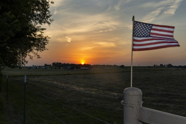An American flag on the fence of a farm near the city of Commerce in the State of Oklahoma