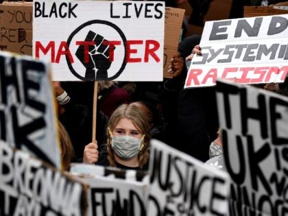 Protesters hold placards as they attend a demonstration in Parliament Square in central London on June 6, 2020, to show solidarity with the Black Lives Matter movement in the wake of the killing of George Floyd, an unarmed black man who died after a police officer knelt on his neck …