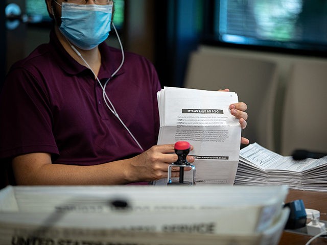 Absentee ballot election workers stuff ballot applications at the Mecklenburg County Board of Elections office in Charlotte, North Carolina on September 4, 2020. - The US election is officially open: North Carolina on September 4, 2020 launched vote-by-mail operations for the November 3 contest between President Donald Trump and Joe …