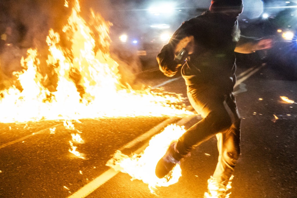 A protester, whos feet caught fire after a molotov cocktail exploded on him, runs toward a medic during a protest on September 5, 2020 in Portland, Oregon. (Nathan Howard/Getty Images)