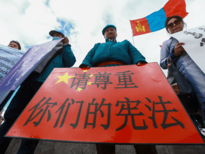 A Mongolian man holds a protest banner in the shape of the Chinese flag which reads "Respect your constitution" during a protest against China's plan to introduce Mandarin-only classes at schools in the Chinese province of Inner Mongolia, at Sukhbaatar Square in Ulaanbaatar, the capital of Mongolia on September 15, …