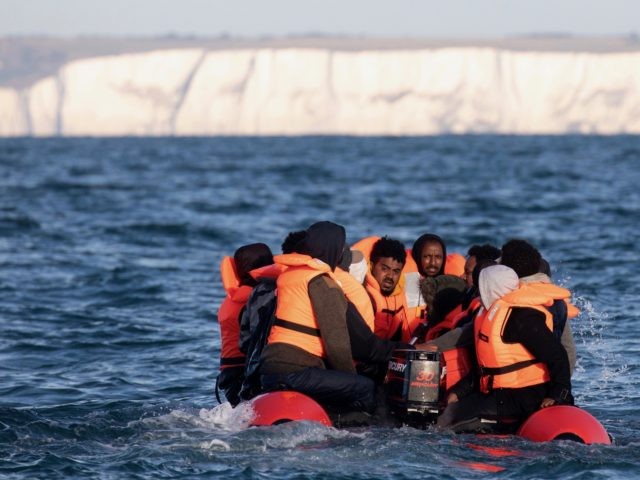 AT SEA, UNITED KINGDOM - SEPTEMBER 07: Migrants packed tightly onto a small inflatable boat attempt to cross the English Channel near the Dover Strait, the world's busiest shipping lane, on September 07, 2020 off the coast of Dover, England. Last Wednesday, more than 400 migrants made the journey from …