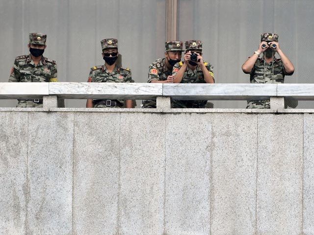 PANMUNJOM, SOUTH KOREA - SEPTEMBER 16: North Korean army soldiers wearing masks look at th