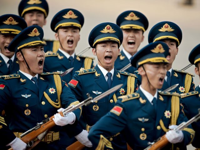 Paramilitary guards shout during a welcoming ceremony for Argentine President Mauricio Macri outside the Great Hall of the People in Beijing on May 17, 2017. Macri is on a state visit to China after attending the Belt and Road Forum on May 14-15. / AFP PHOTO / POOL / Nicolas …