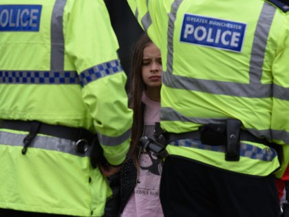 TOPSHOT - A woman and a young girl wearing a t-shirt of US singer Ariana Grande talks to police near Manchester Arena following a deadly terror attack in Manchester, northwest England on May 23, 2017. Twenty two people have been killed and dozens injured in Britain's deadliest terror attack in …