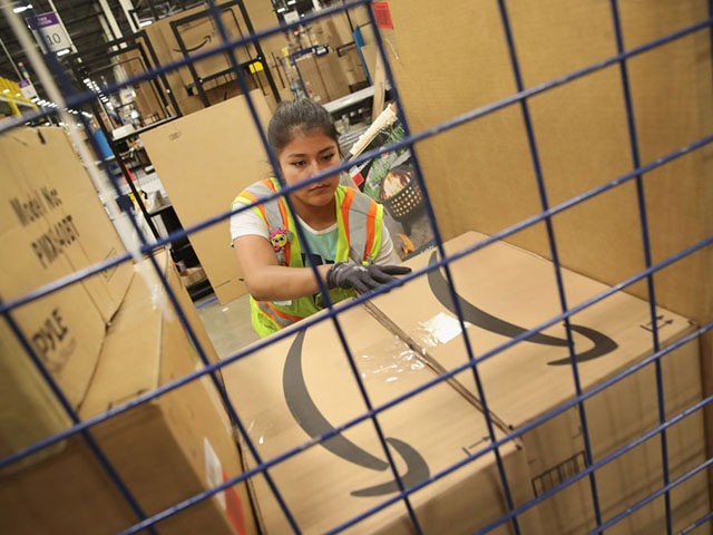 ROMEOVILLE, IL - AUGUST 01: Workers pack and ship customer orders at the 750,000-square-foot Amazon fulfillment center on August 1, 2017 in Romeoville, Illinois. On August 2, Amazon will be holding job fairs at several fulfillment centers around the country, including the Romeoville facility, in an attempt to hire more …