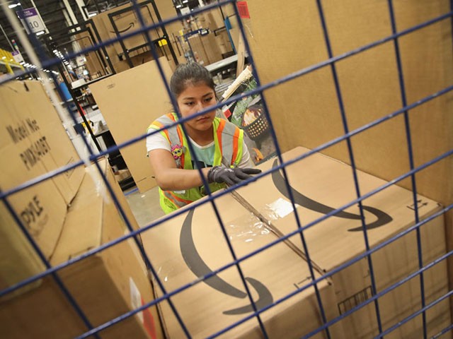 ROMEOVILLE, IL - AUGUST 01: Workers pack and ship customer orders at the 750,000-square-foot Amazon fulfillment center on August 1, 2017 in Romeoville, Illinois. On August 2, Amazon will be holding job fairs at several fulfillment centers around the country, including the Romeoville facility, in an attempt to hire more than 50,000 workers. (Photo by Scott Olson/Getty Images)